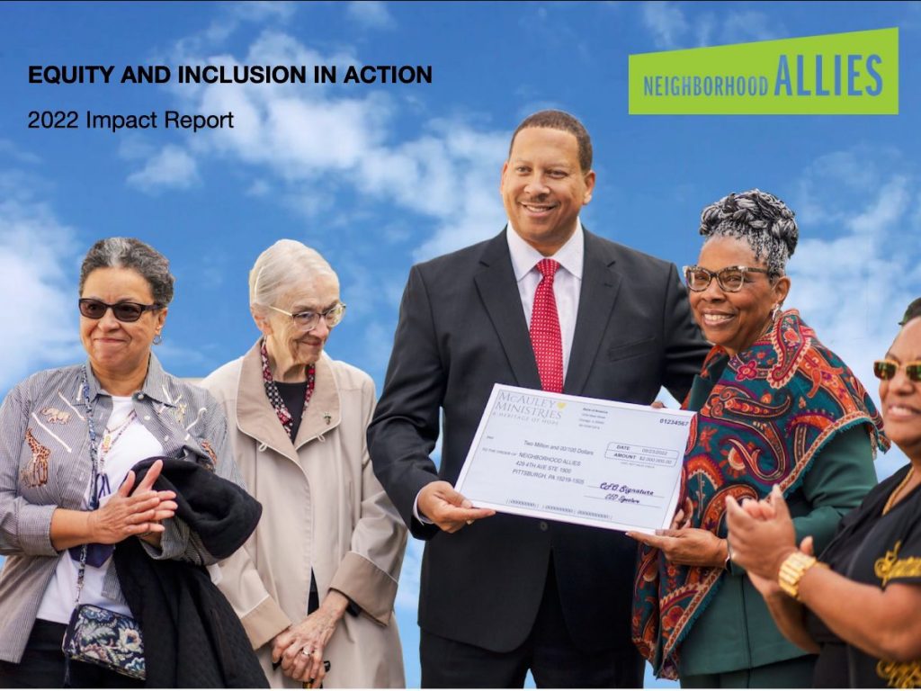 Screenshot image of the front page of the annual impact report. It features blue sky and clouds in the background, and a cut-out image of Presley, our President and CEO, standing with board members and staff of McAuley Ministries, accepting a check for a $1 million grant. Everyone is smiling and several people clap. 